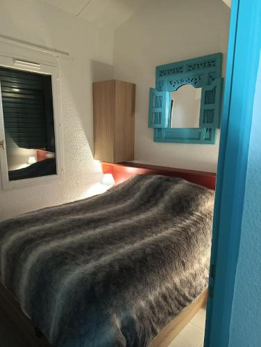 une chambre avec un grand lit et un miroir dans l'établissement Maisonnette Bleue Bora-Bora, à Argelès-sur-Mer