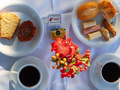 Pousada dos Coqueiros في بورتو دي غالينهاس: طاولة مع طبقين من الطعام وكوبين من القهوة