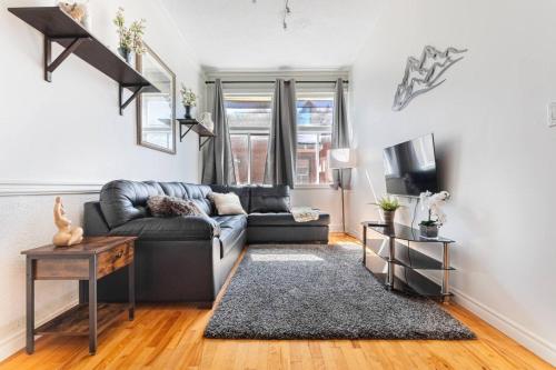 a living room with a couch and a tv at Trendy 2BR Getaway in Montreal in Montréal