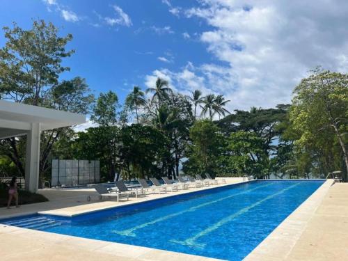 a large swimming pool with chairs and trees at Punta Esmeralda Paradise in Tarcoles