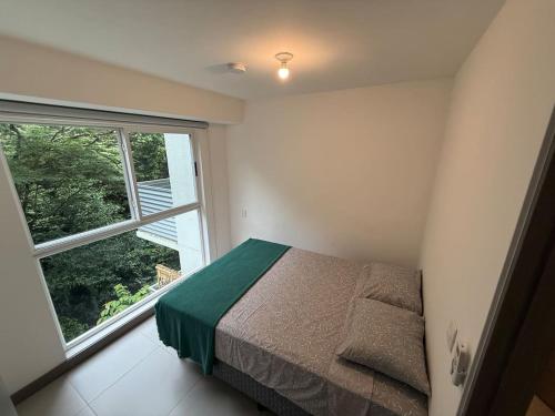 a bedroom with a bed and a large window at Punta Esmeralda Paradise in Tarcoles