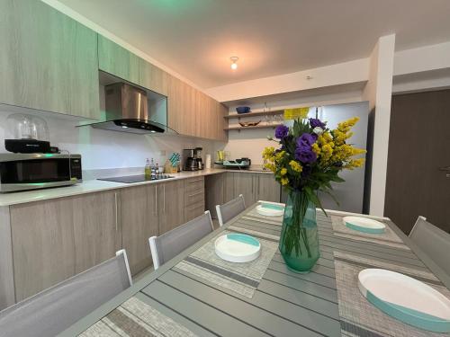 a kitchen with a table with a vase of flowers on it at Punta Esmeralda Paradise in Tarcoles