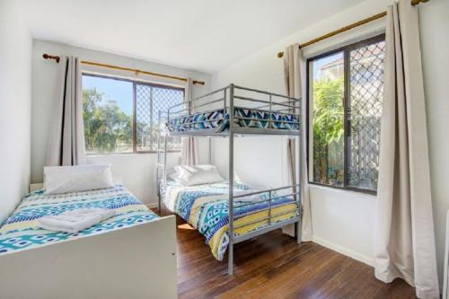 a bedroom with two bunk beds and a window at Sunny Somerset 2B located opp Byron Bay markets in Byron Bay