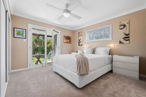 - une chambre avec un lit blanc et une porte coulissante en verre dans l'établissement Bels Florida Family Getaway - Pool, WiFi, BBQ, à Gold Coast