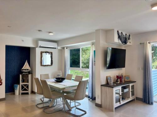 a dining room with a table and chairs and a television at Esmeralda apartment in Tarcoles