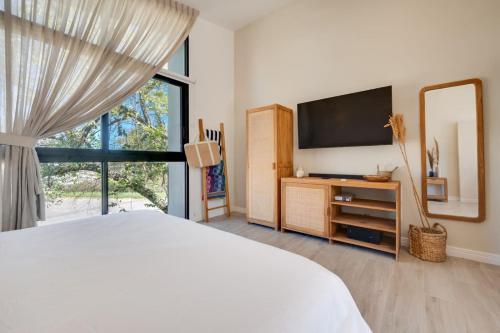 a bedroom with a bed and a tv and a window at The Bungalows #4 - Boutique Hotel in Flamingo Beach - Top Level Studio in Playa Flamingo
