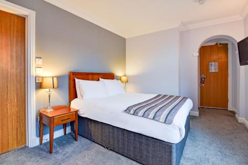 a hotel room with a bed and a nightstand with a table at Aston Court Derby City Centre by Belvilla in Derby