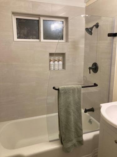 a bathroom with a shower and a bath tub with a towel at Cozy Hideaway and Hot Tub. Pet Friendly. in Eureka