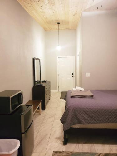 a bedroom with a bed and a tv and a door at TigerMinnow Coles Lodge in Carrabelle