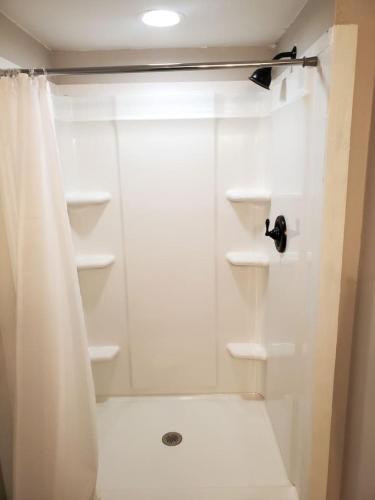 a bathroom with a shower with a shower curtain at TigerMinnow Coles Lodge in Carrabelle