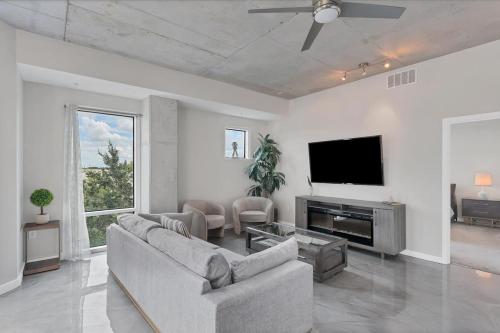 a living room with a couch and a flat screen tv at Modern 3 bedroom condo in downtown w free parking in Orlando