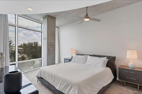 a bedroom with a white bed and a large window at Modern 3 bedroom condo in downtown w free parking in Orlando