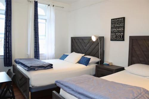 a bedroom with two beds and a sign on the wall at KLO Guest House in Brooklyn