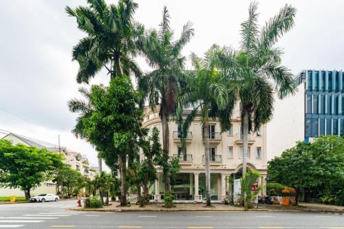 a building with palm trees in front of a street at Collection O Sunshine Garden Hotel - Near SECC in Ho Chi Minh City