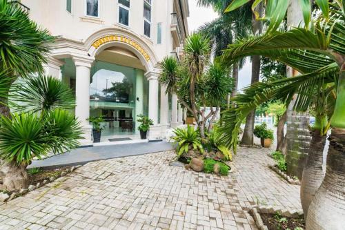 a building with palm trees in front of it at Collection O Sunshine Garden Hotel - Near SECC in Ho Chi Minh City