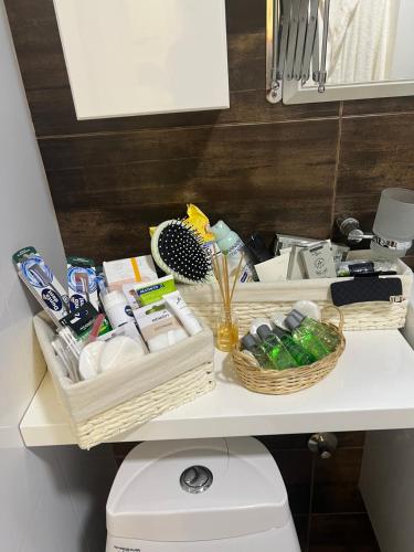 a bathroom shelf with baskets on top of a toilet at Mona Lux apartman in Arandelovac