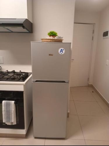 a white refrigerator in a kitchen with a plant on top at Cozy Mellenial Umhlanga studio in Durban