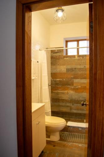 a bathroom with a toilet and a wooden wall at Hotel Monasterio San Pedro in Cusco