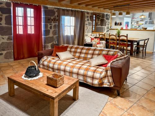 un salon avec un canapé et une table dans l'établissement Le refuge de la vallée - 4 à 6 pers - proche de Salers, à Saint-Projet-de-Salers