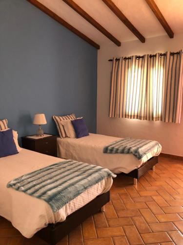 a bedroom with two beds and a window at Monte Novo da Longueira Turismo Rural in Longueira