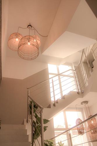 two chandeliers hanging from a ceiling with stairs at Résidence Alissa Charleroi Airport in Charleroi