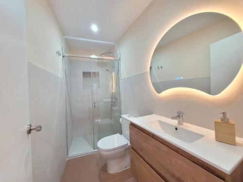 a bathroom with a sink and a toilet and a mirror at Casa La Aurora in Vejer de la Frontera