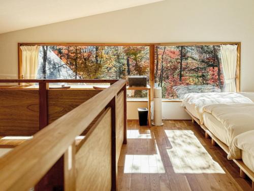 a bedroom with a bed and a large window at Karuizawa Mori Shiki VILLA - Vacation STAY 57077v in Kutsukake