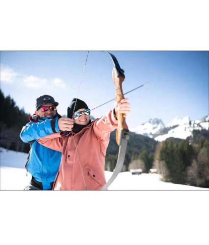 a man and woman holding a bow and arrow at Les Crêtes in Vionnaz