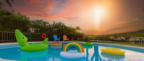 a swimming pool with a rainbow and inflatables at Lakefront Retreat Perfect for Family Fun in Miami