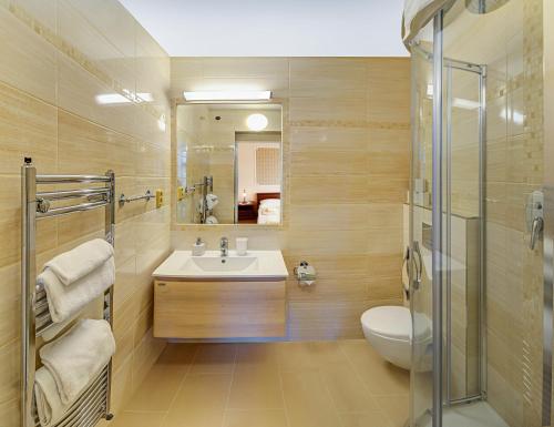 a bathroom with a sink and a toilet and a mirror at LD Morava in Karlovy Vary