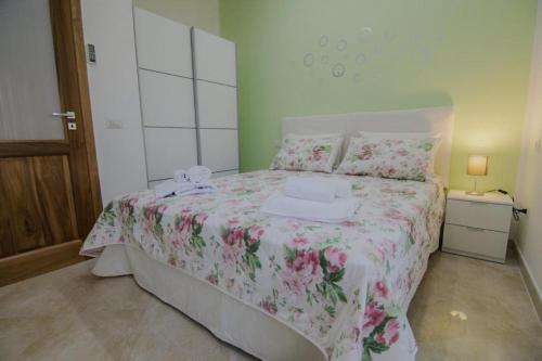 a bedroom with a bed with a pink floral bedspread at Casa Vacanze Anna & Giulia in Torchiara