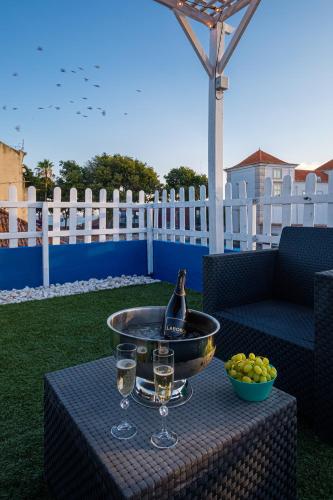 a birdbath on a table with glasses and a bowl of fruit at Y Quebedo - Boutique Apartments in Setúbal