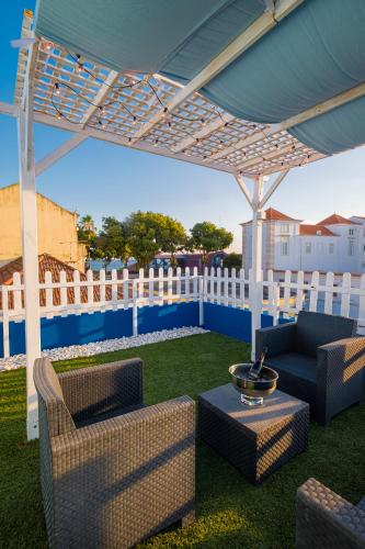 a patio with chairs and a table under a canopy at Y Quebedo - Boutique Apartments in Setúbal