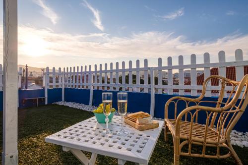 a table with two chairs and glasses on a balcony at Y Quebedo - Boutique Apartments in Setúbal