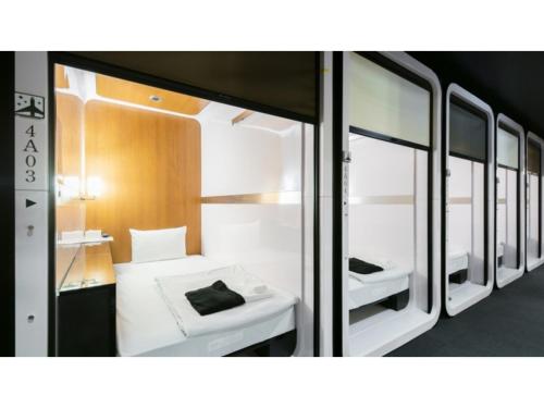 東京にあるFirst Cabin Ichigaya "Capsule room only" - Vacation STAY 57106vのベッドと鏡がいくつかある小さな部屋