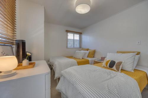 a room with three beds and a table with a lamp at 221CL 221 Claressa Ave in Avalon