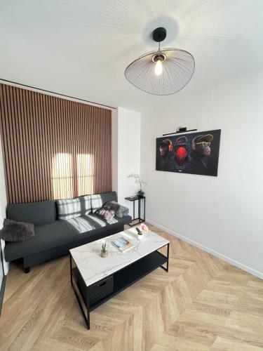 a living room with a couch and a coffee table at Superbe appartement neuf 2 pièces Vincennes pte de Paris in Montreuil