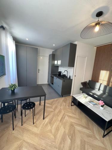 un salon avec une table et un canapé dans l'établissement Superbe appartement neuf 2 pièces Vincennes pte de Paris, à Montreuil