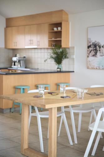 a kitchen with a wooden table and chairs at Waves for Daze in Middleton