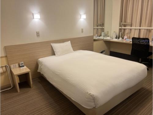 una camera d'albergo con un letto e una scrivania di Smile Hotel Shirakawa - Vacation STAY 68138v a Nishigo