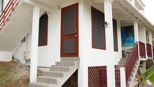a white house with stairs and a wooden door at Pebble Coin in Corinthe
