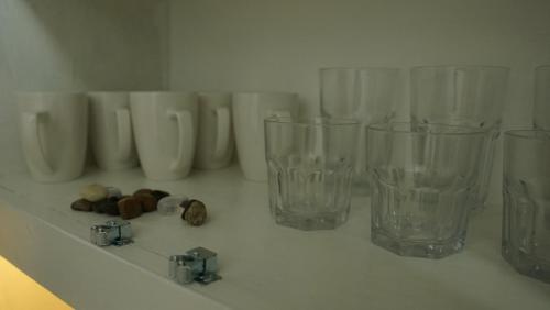 a group of glass vases sitting on a shelf at Pebble Coin in Corinthe