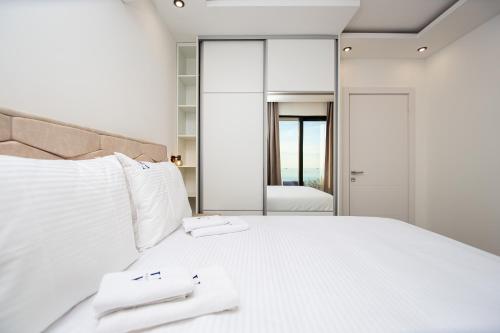 a bedroom with a large white bed with mirrors at Villa Aurora Azure - Luxury Infinity Pool Resort in Katun