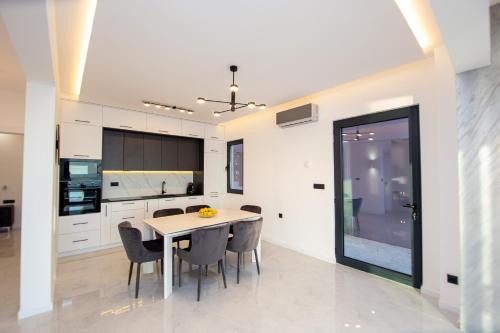 a kitchen and dining room with a table and chairs at Villa Aurora Azure - Luxury Infinity Pool Resort in Katun