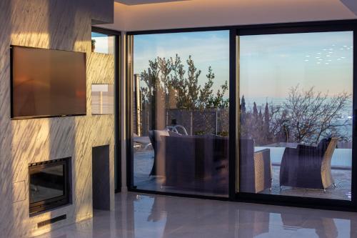 a living room with a fireplace and a television at Villa Aurora Azure - Luxury Infinity Pool Resort in Katun