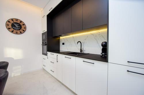 a kitchen with white cabinets and a sink at Villa Aurora Azure - Luxury Infinity Pool Resort in Katun