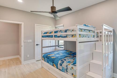 a bedroom with two bunk beds and a ceiling fan at Walk to Shore Modern Stunner in Ormond Beach! in Ormond Beach