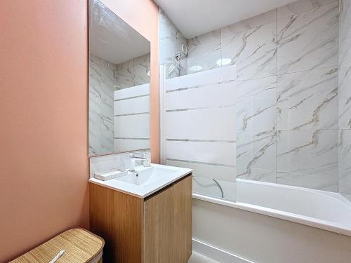 a bathroom with a sink and a bath tub at Coup de cœur in Grande-Synthe
