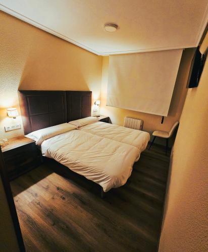 a hotel room with a large bed and two tables at El Camarote in Cudillero