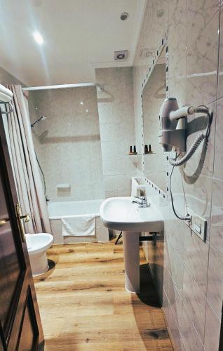 a bathroom with a sink and a toilet and a tub at El Camarote in Cudillero